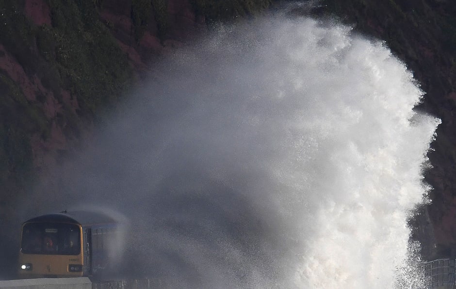 Waves hit a train during heavy seas and high winds in Dawlish in southwest Britain. PHOTO: REUTERS