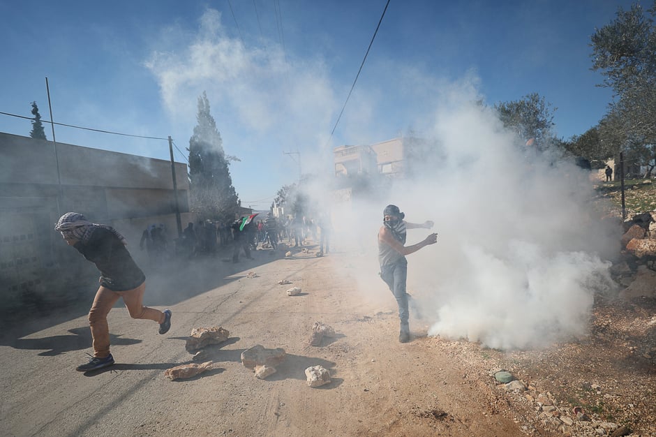 A Palestinian protester throws back a tear gas canister fired by Israeli troops during clashes following a protest against the near-by Jewish settlement of Qadomem, in the West Bank village of Kofr Qadom near Nablus. PHOTO: REUTERS