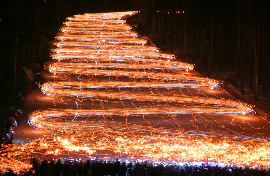 Hundreds of skiers and snowboarders descend from a slope while holding lit torches and flashlights in the Siberian town of Zheleznogorsk, northeast of Krasnoyarsk, Russia. PHOTO: REUTERS