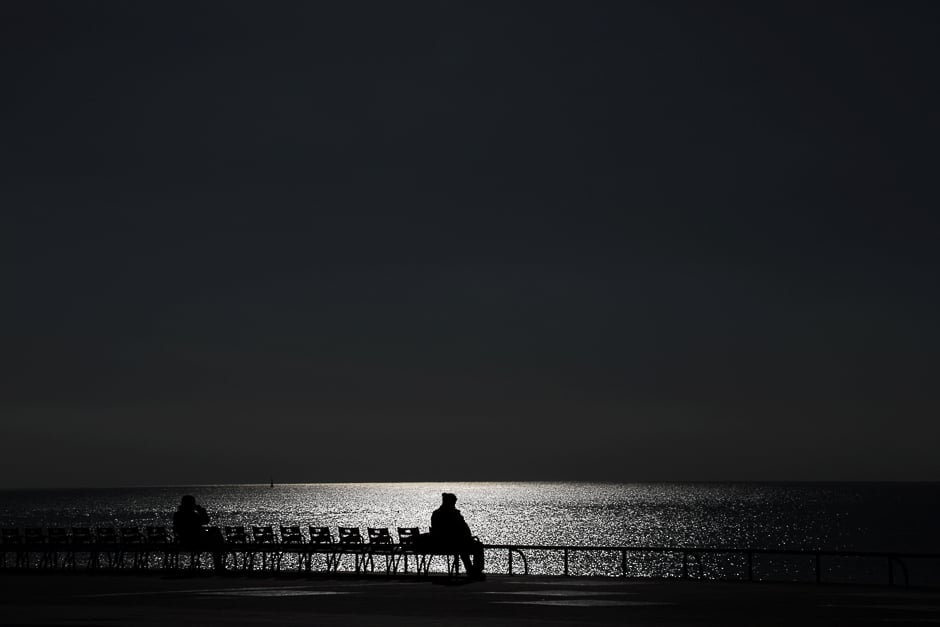 Sunlight reflects on the water's surface as people sit on chairs on a warm and sunny day on the Promenade Des Anglais in Nice, France. PHOTO: REUTERS