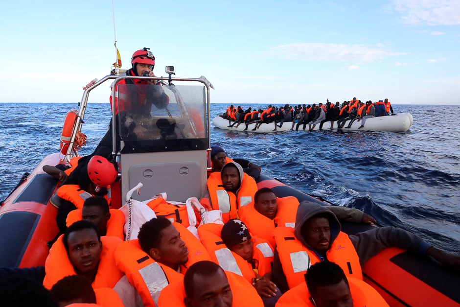 Sub-saharan migrants are seen aboard an overcrowded raft as others are seen onboard a rescue boat, during a rescue operation by the Spanish NGO Proactiva Open Arms in the central Mediterranean Sea, 21 miles north of the coastal Libyan city of Sabratha. PHOTO: REUTERS