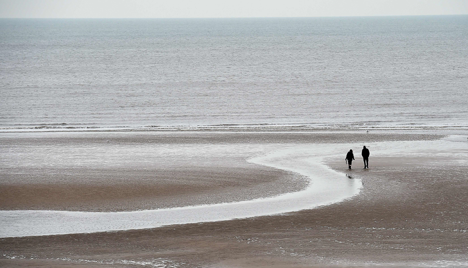 People walk on the beach in Blackpool, northwest England. PHOTO: AFP