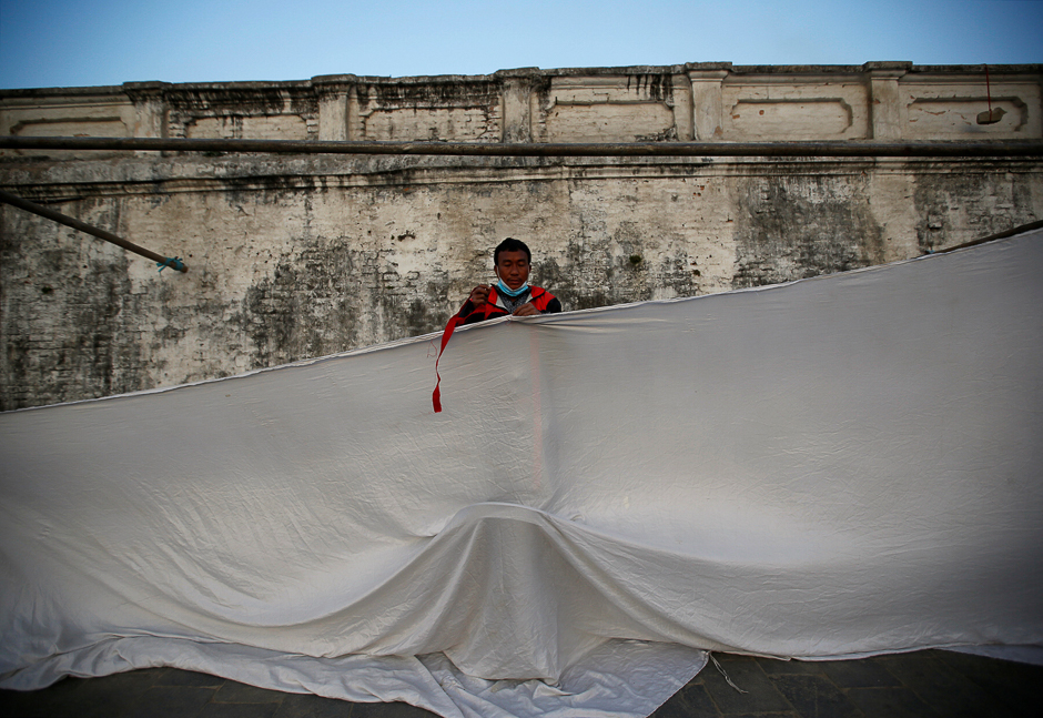 A man works to set up a curtain at the premises of Pashupatinath Temple in Kathmandu, Nepal. PHOTO: REUTERS