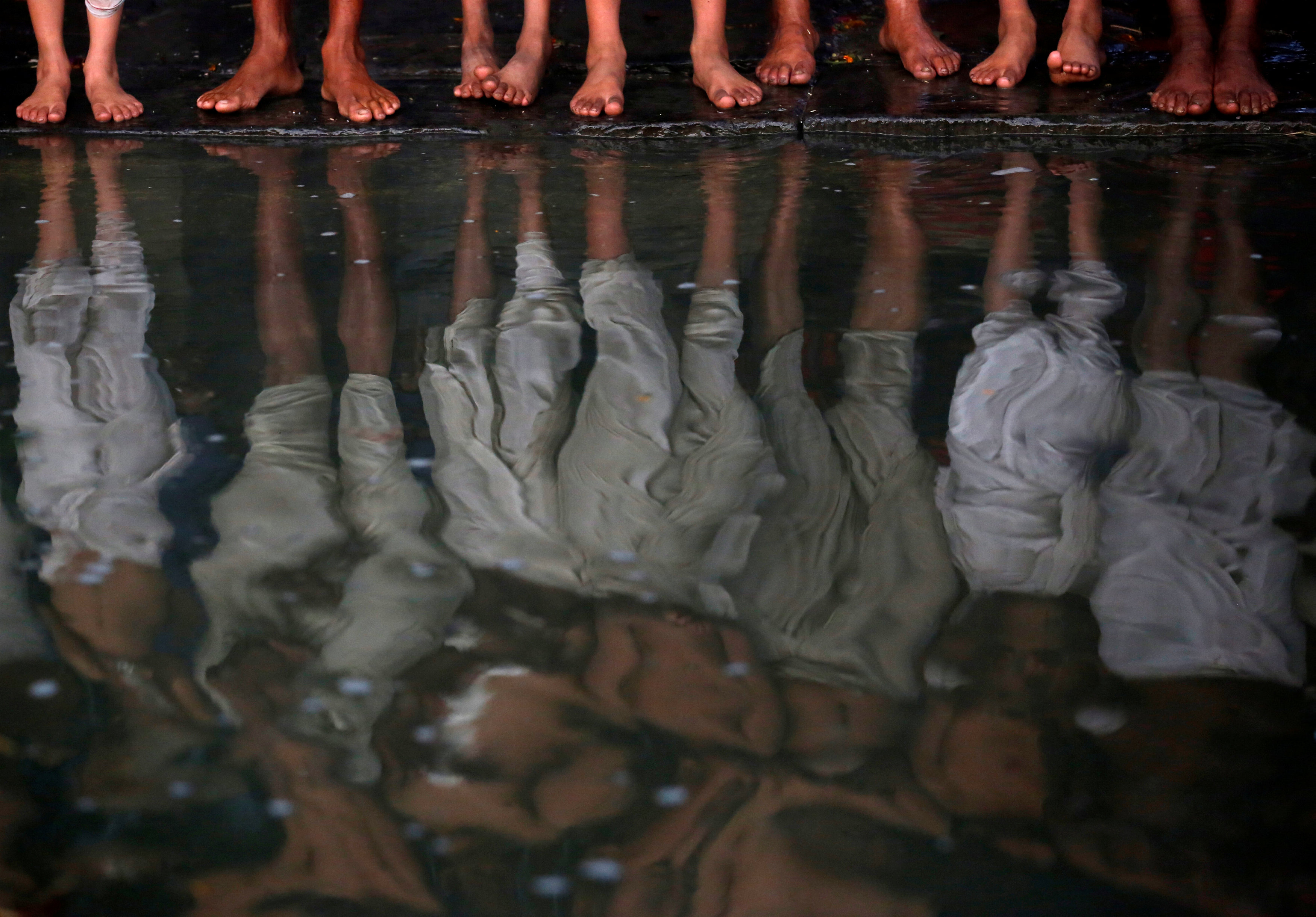 The feet of devotees are pictured as they stand on the bank of the Hanumante River during the Swasthani Brata Katha festival in Bhaktapur, Nepal January 13, 2017. REUTERS/Navesh Chitrakar