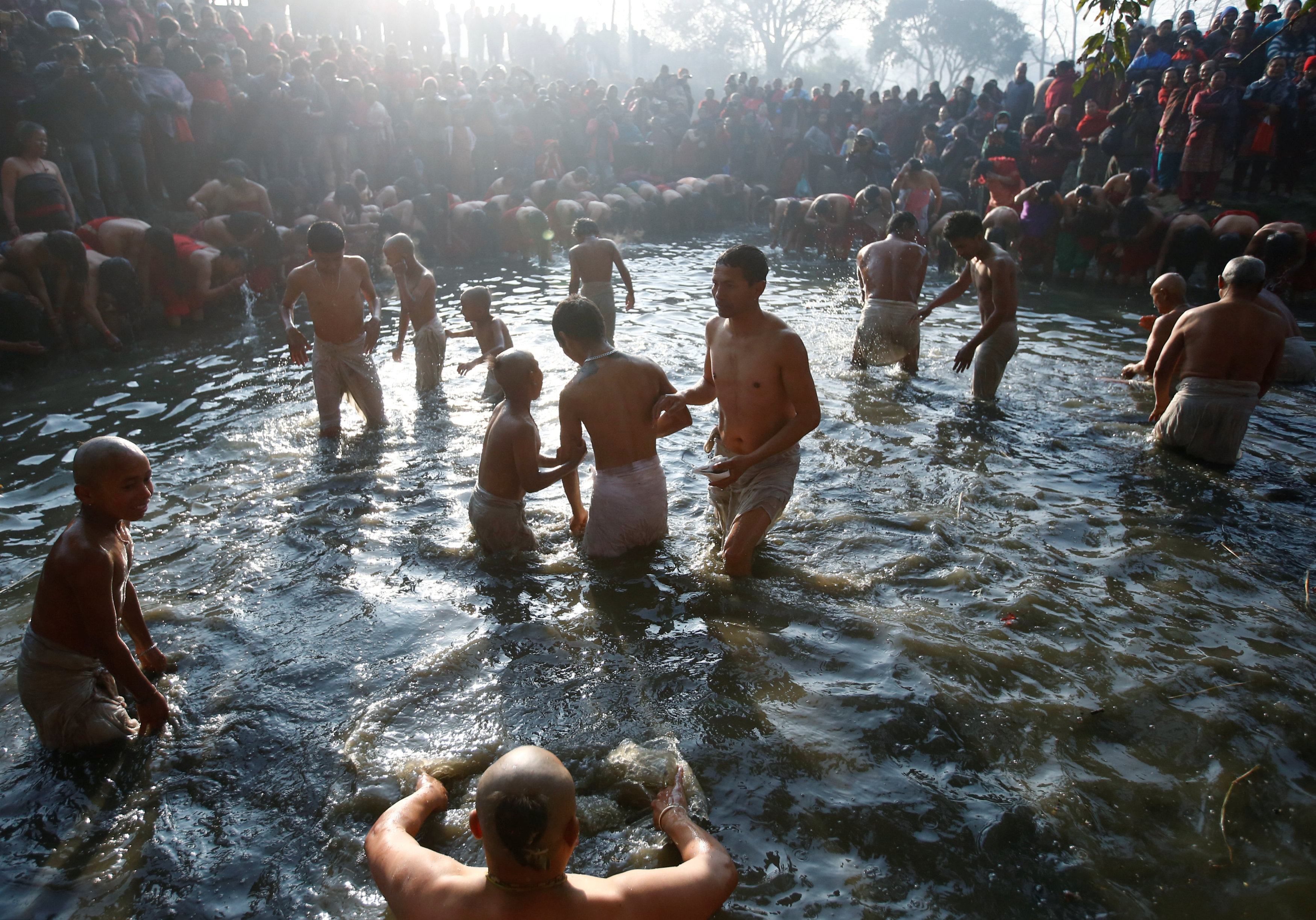 Devotees offer prayers by taking a bath in the Hanumante River, on the final day of the month-long Swasthani Brata Katha festival in Bhaktapur, Nepal February 10, 2017. REUTERS/Navesh Chitrakar