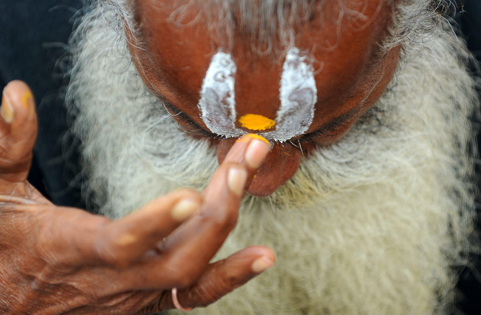 A Nepalese Hindu Sadhu (Holy man) smears coloured paste onto his forehead near the Pashupatinath Temple during the Hindu festival Maha Shivaratri in Kathmandu. PHOTO: AFP