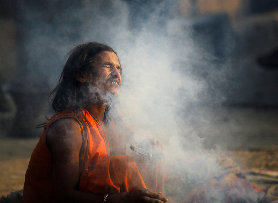A Hindu holy man, or sadhu, closes his eyes as smoke covers his face at the premises of Pashupatinath Temple in Kathmandu, Nepal. PHOTO: REUTERS