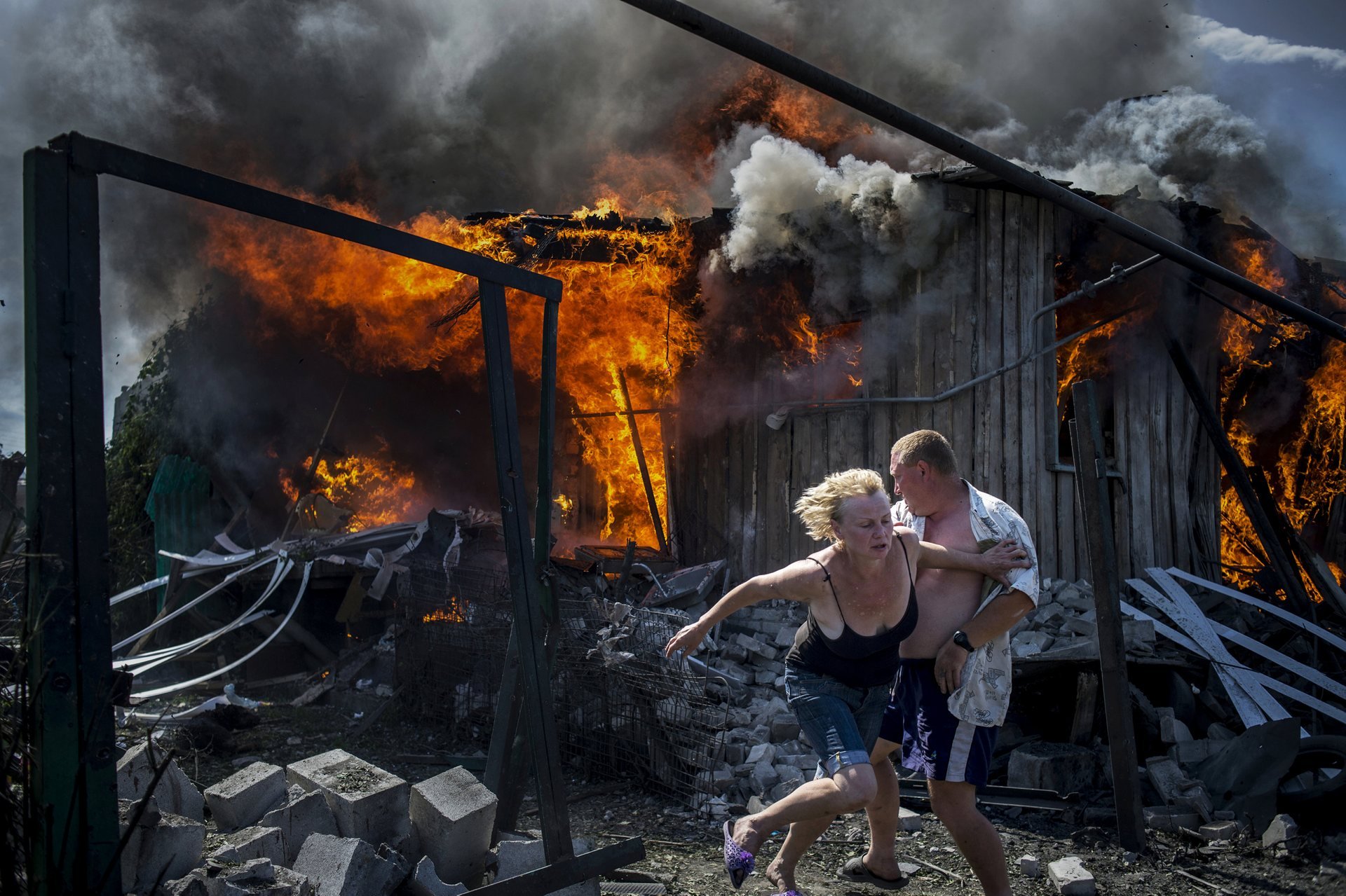 Long-term projects â first prize Residents escape from a fire at a house destroyed by an air attack in the village of Luhanskaya, Ukraine Photograph: Valery Melnikov/Rossiya Segodnya