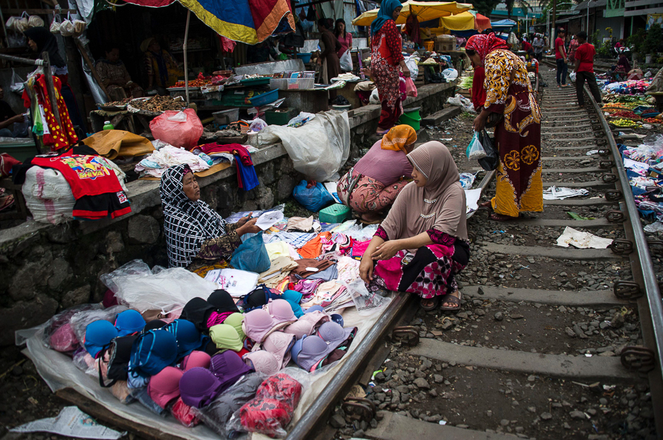 Indonesians shop at a makeshift market that uses empty space along a railway line in Surabaya, in eastern Java Island. PHOTO: AFP