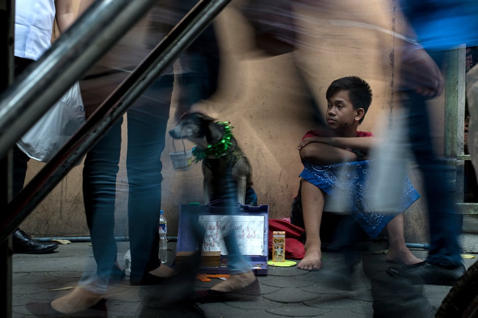 A boy and his dog beg for alms along a street in Manila. PHOTO: AFP