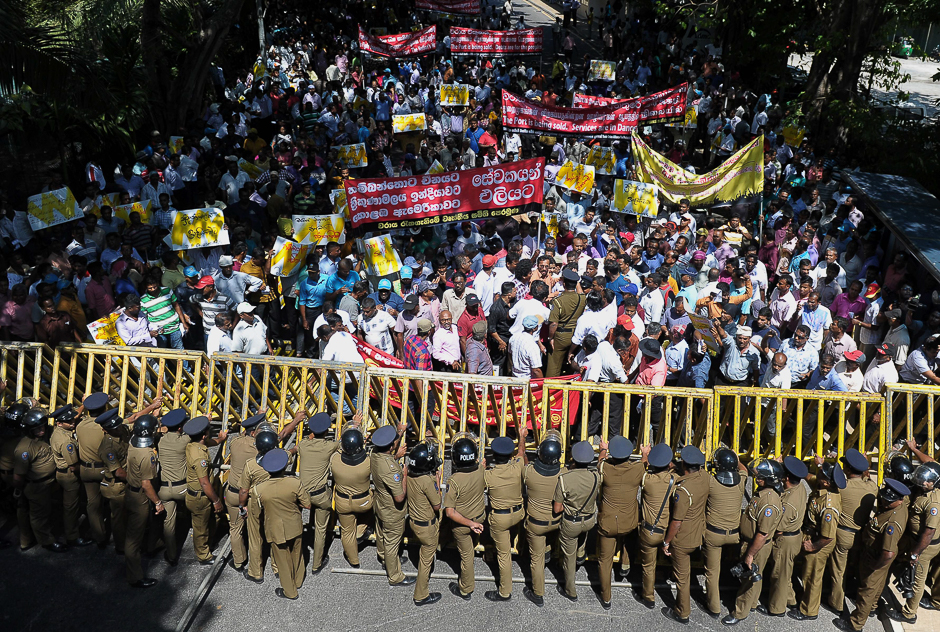 Sri Lankan police stand guard during a protest against the proposed sale of a stake in a loss-making port to a Chinese company in Colombo. PHOTO: AFP