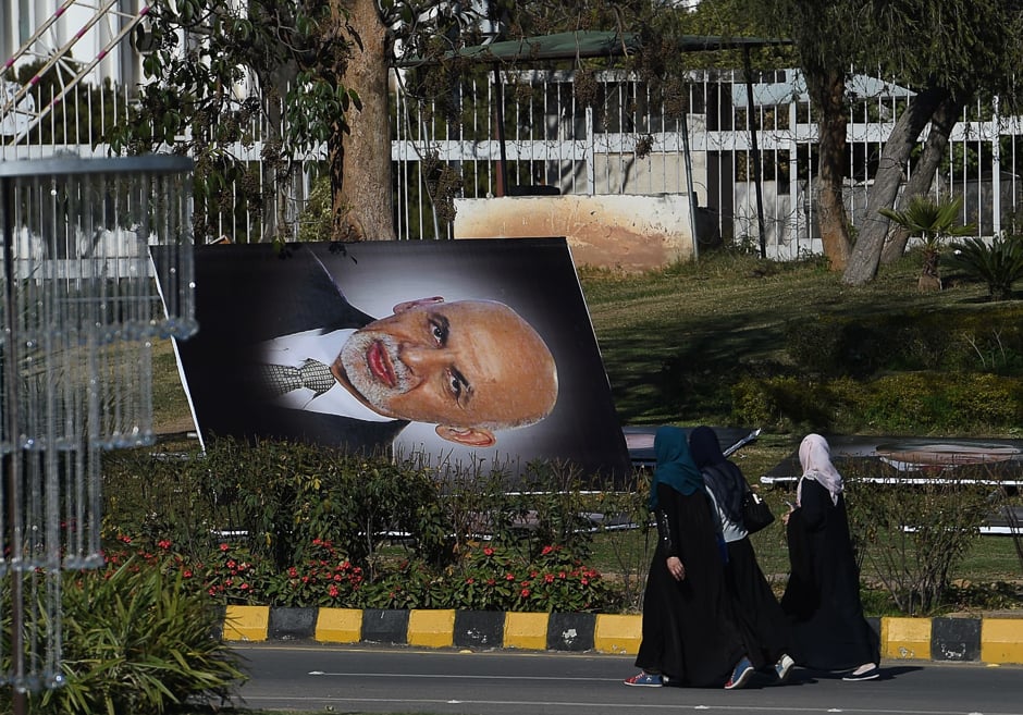 Pakistani pedestrians walk past a portrait of Afghan President Ashraf Ghani before it is installed on a street in Islamabad. PHOTO: AFP 5.Palestinian women take a selfie in Gaza City's seaport during heavy fog. PHOTO: AFP 