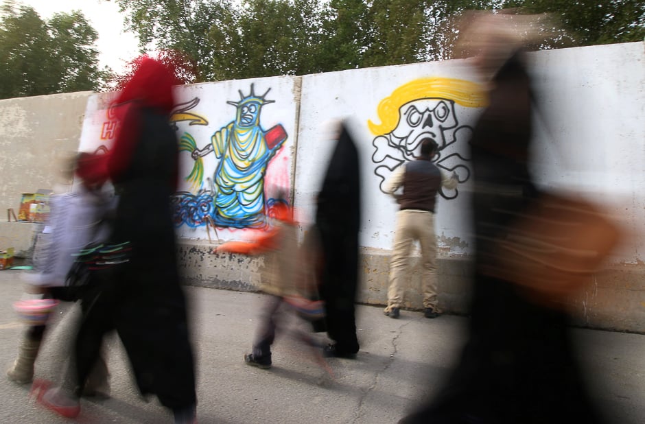 An Iraqi graffiti artist sprays a cement wall with anti-US President Donald Trump slogans in the southern Iraqi city of Basra. PHOTO: AFP