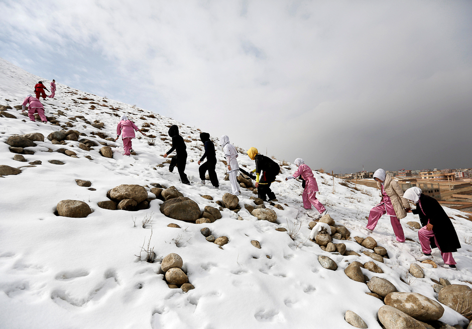 Students climb a hill as they arrive to practice in Kabul. PHOTO: REUTERS