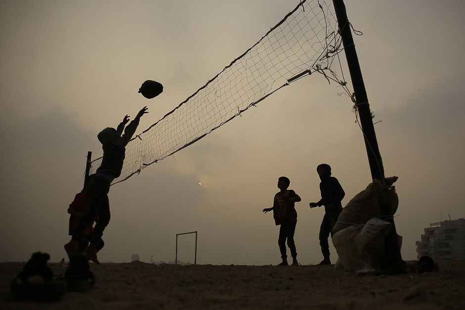 Palestinian boys play volleyball with plastic homemade ball near their homes in Gaza City. PHOTO: AFP
