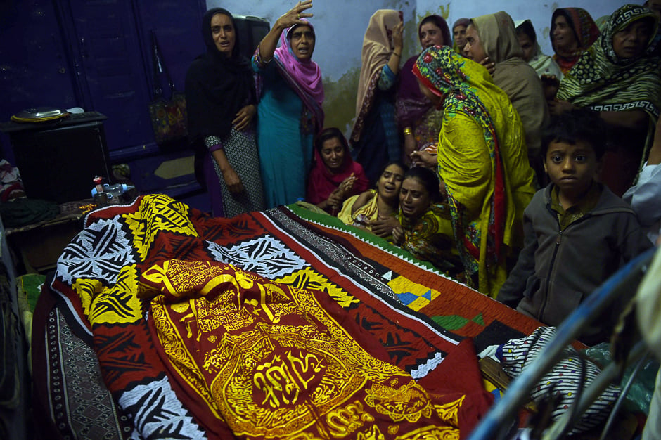 Relatives mourn over the coffin of a 13-year-old blast victim Zeeshan during his funeral in the town of Sehwan. PHOTO: AFP