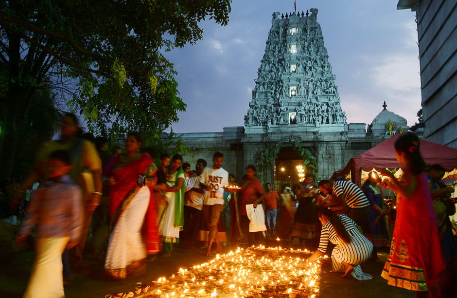Sri Lankan Hindu devotee offers prayers while holding an oil lamp at a Hindu temple in Colombo. PHOTO: AFP