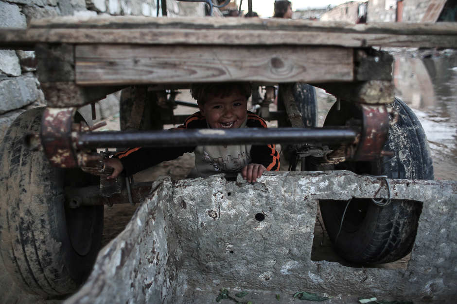 A Palestinian boy plays under a donkey cart outside his house in an impoverished area in the southern Gaza Strip town of Khan Yunis. PHOTO: AFP