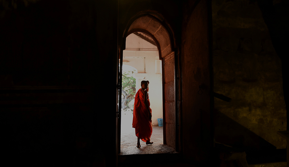 A Buddhist monk looks over into a natural cave at the Rock Temple, also known as the Rangiri Dambulla Rajamaha Viharaya, in Dambulla, some 150 kms north of the capital Colombo. PHOTO: AFP