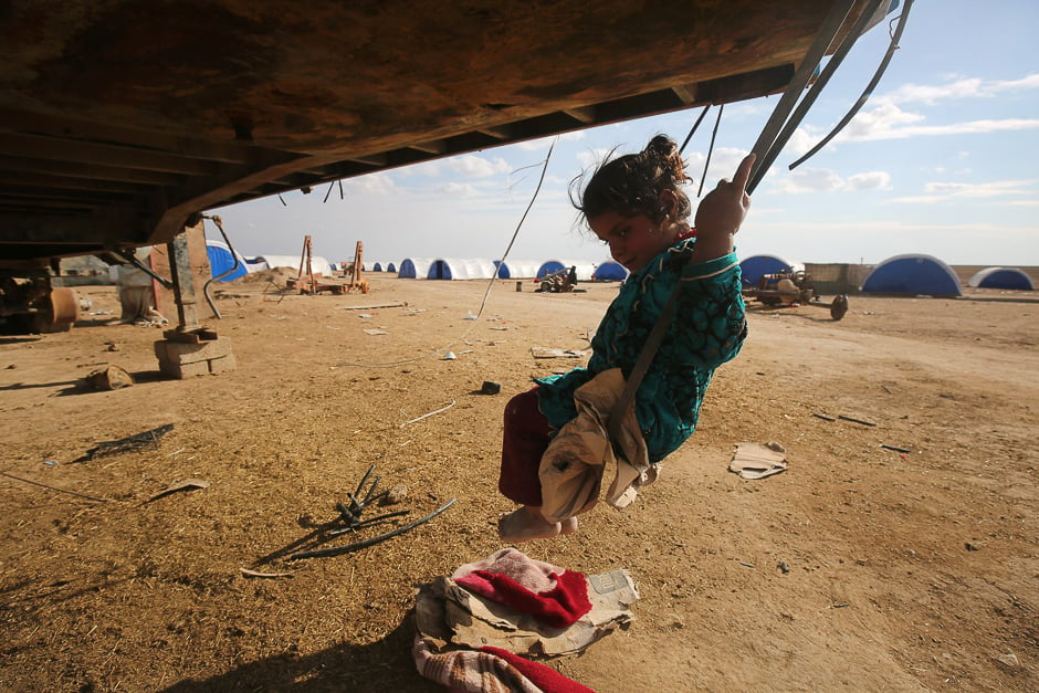 A displaced Iraqi girl plays on a swing at the Al-Agha camp where Iraqi families from the nearby villages of Tal Afar, southwest of Mosul, are taking shelter as Iraqi forces. PHOTO: AFP