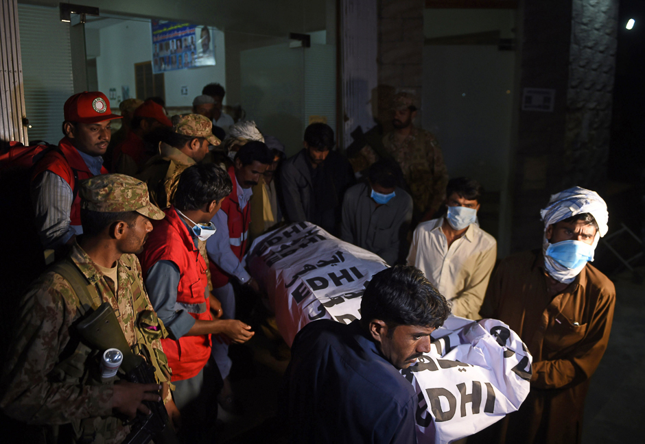 Volunteers carry the body of a victim from a hospital in the town of Sehwan, a day after the bomb attack. PHOTO: AFP