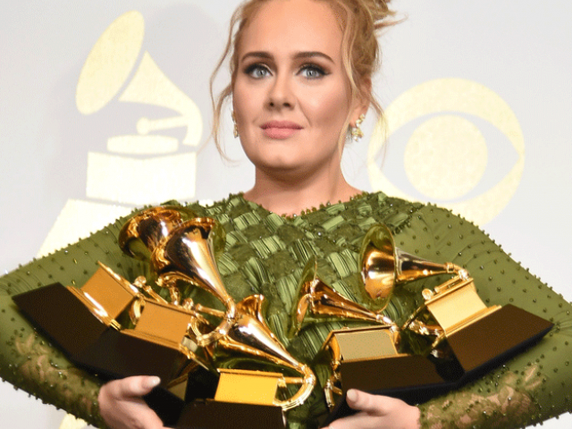 Adele poses in the press room with her trophies. PHOTO: AFP