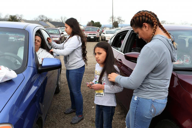 Violet Orozco (2nd R), 9, has her hair brushed by her sister Bertha (R), of Gridley, California, at a Red Cross relief centre in Chico, California, after an evacuation was ordered for communities downstream from the Lake Oroville Dam, in Oroville, California, US February 13, 2017. PHOTO: REUTERS