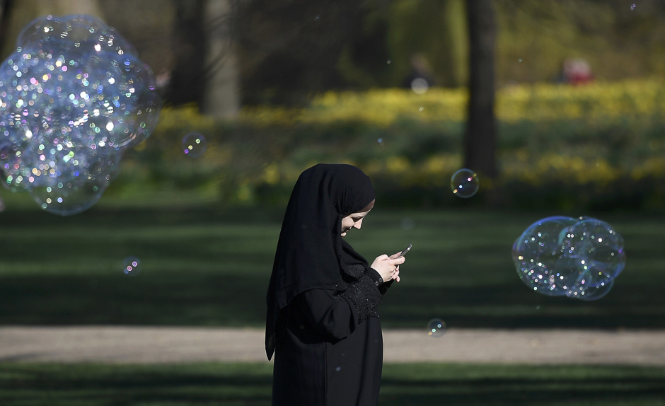 A woman walks past soap bubbles in the spring sunshine in St. James's Park in London, Britain. PHOTO: REUTERS