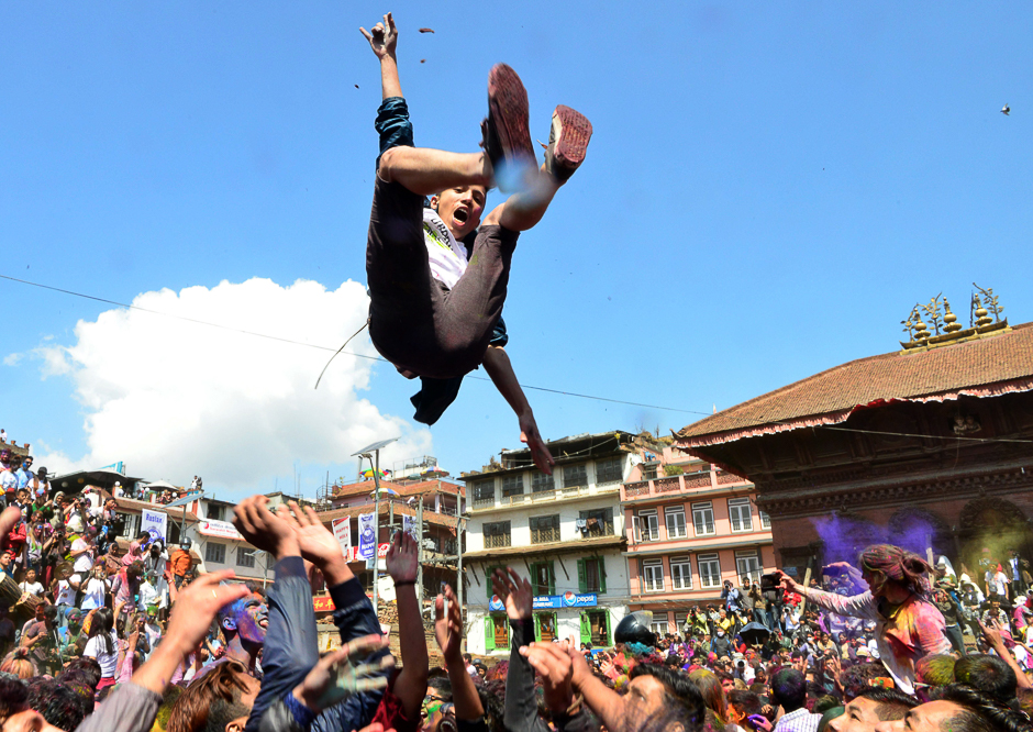 A reveller is tossed into the air as they celebrate the Holi spring festival in Kathmandu. PHOTO: AFP