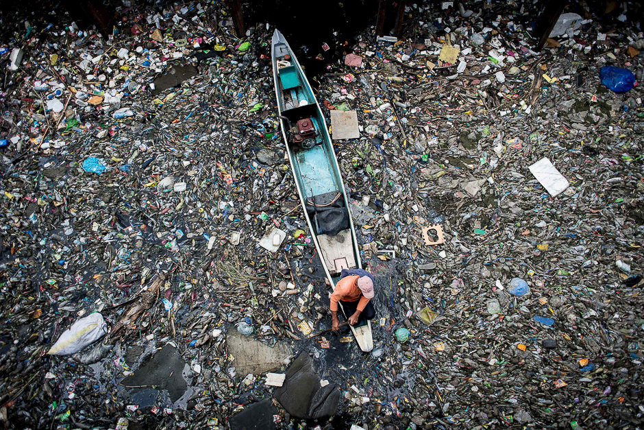 A worker collects garbage from the Marilao River in Bulacan, north of Manila. PHOTO: AFP