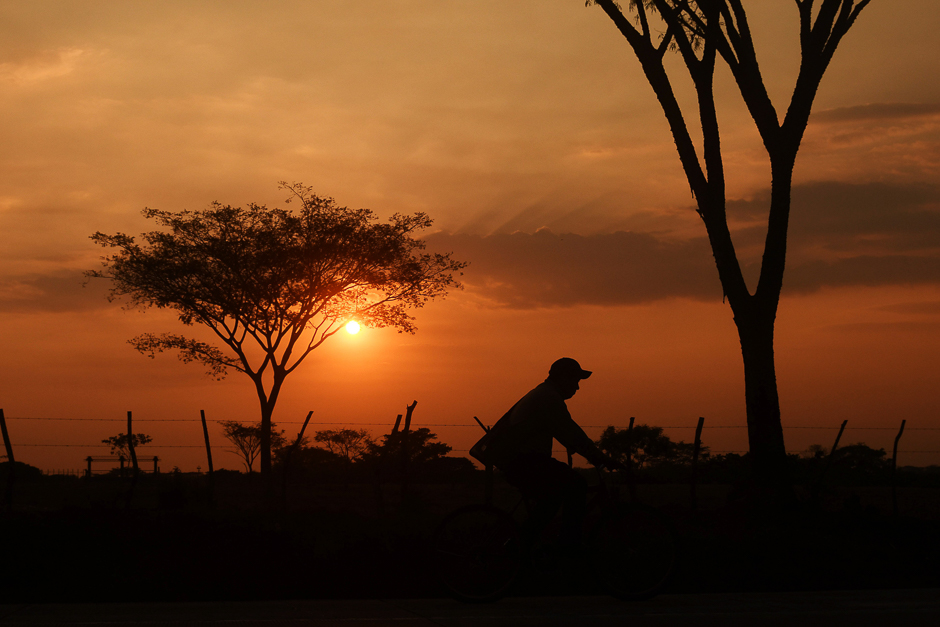 A man rides his bicycle at sunset in San Marcos Lempa, 84 km from San Salvador. PHOTO: AFP