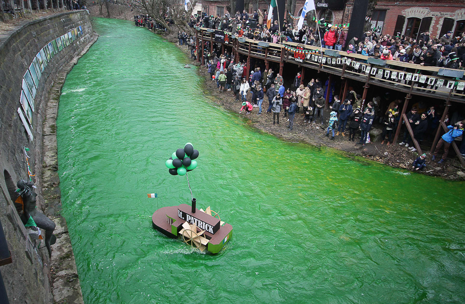 People stand along the Vilnia river which is coloured in green to celebrate the Irish festivity Saint Patrick's Day in Vilnius, Lithuania. PHOTO: AFP