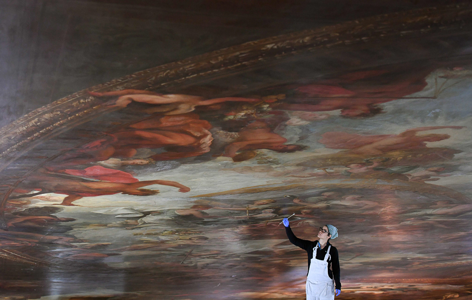 A conservator poses during a photocall to promote the restoration project of the ceiling of the Painted Hall, at the Old Royal Naval College in Greenwich, London. PHOTO: AFP