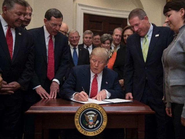 US President Donald Trump (C) signs the the Waters of the US (WOTUS) executive order, aimed at killing the Obama administration's contentious Clean Water Rule at the White House in Washington, DC, February 28, 2017. PHOTO: AFP