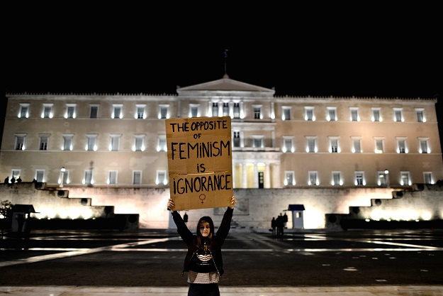 a woman holding a placard stands in front of the parliament building in athens during a demonstration for women 039 s rights on march 8 2017 marking the 40th international women 039 s day photo afp