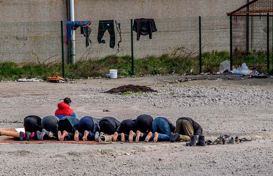 Iraqi Kurds migrants pray in La Liniere camp in Grande-Synthe, northern France where about 1,400-1,500 people stay. PHOTO: AFP