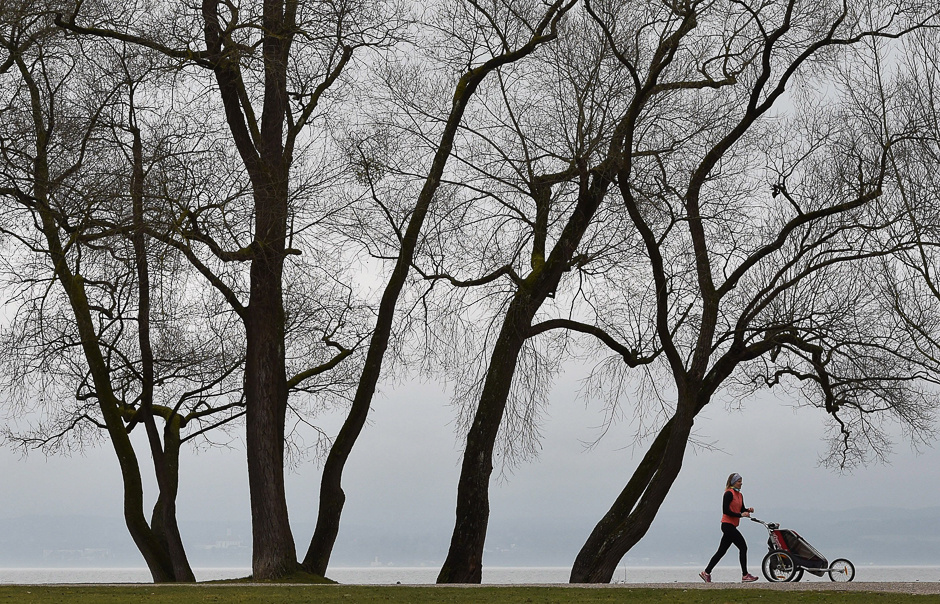 An young girl runs in front of trees during foggy, unsettled weather with temperatures by 10 degrees near the lake Ammersee in Herrsching, southern Germany. PHOTO: AFP