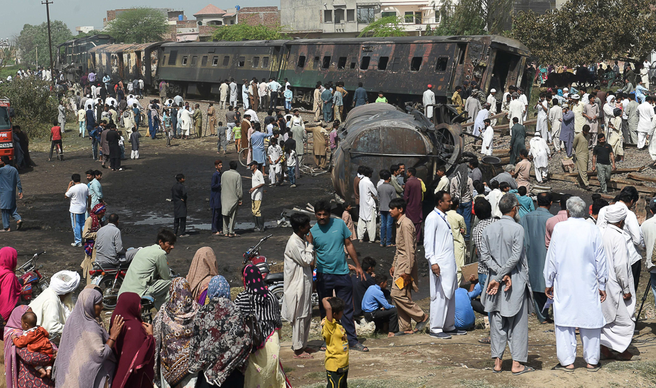 Pakistani residents gather at the site of a collision between a passenger train and an oil tanker in the Sheikhupura district of Punjab Province. PHOTO: AFP