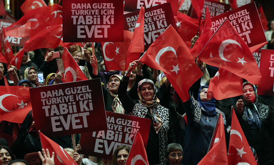 People hold banners and wave Turkish flags during a meeting of Turkish President as part of the campaign for the constitutional referendum in Ankara. PHOTO: AFP