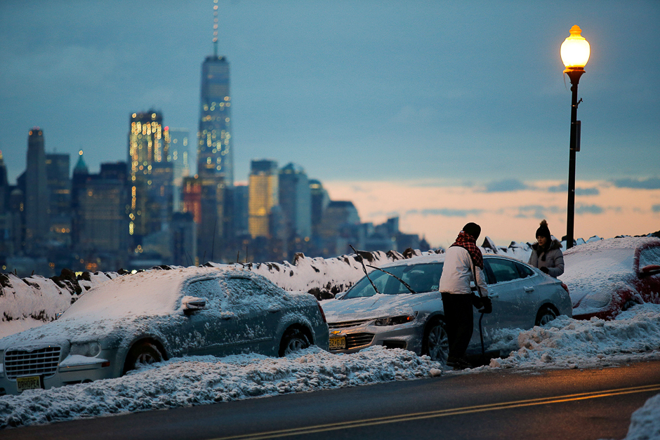 Residents clear their cars and street of snow in Weehawken, New Jersey, as the One World Trade Centre and lower Manhattan are seen after a snowstorm in New York, US. PHOTO: REUTERS