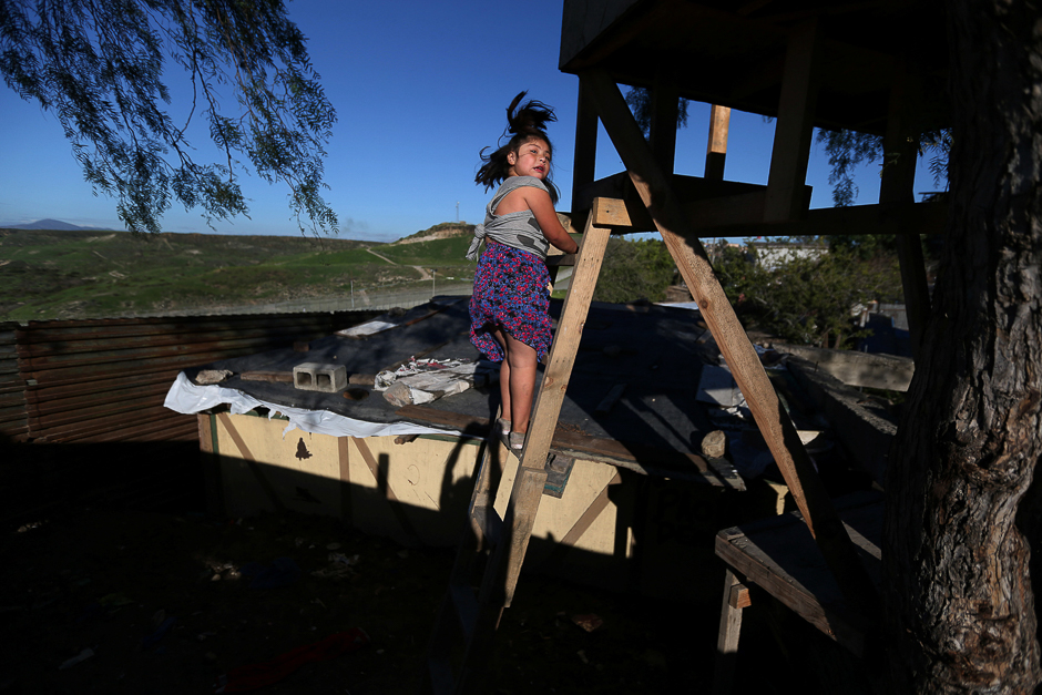 A girl climbs stairs near a section of the fence separating Mexico and the United States, in Tijuana, Mexico. PHOTO: REUTERS