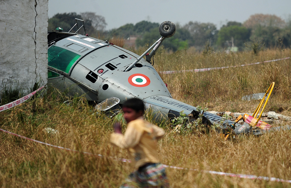 A young Indian boy runs past the wreckage of a Chetak helicopter that crashed while attempting to land in a village near Bamrauli Air Base in Allahabad. PHOTO: AFP