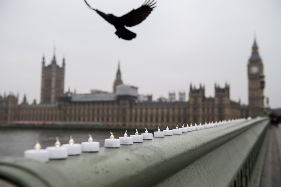 A bird flies over electronic candles left in tribute on Westminster Bridge opposite the Houses of Parliament in central London on March 24, 2017 two days after the March 22 terror attack on the British parliament and Westminster Bridge. PHOTO: AFP