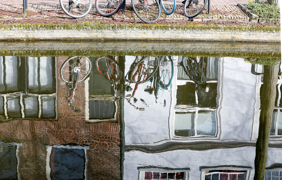 Bicycles are seen reflected in the water of a canal in Delft, Netherlands. PHOTO: REUTERS