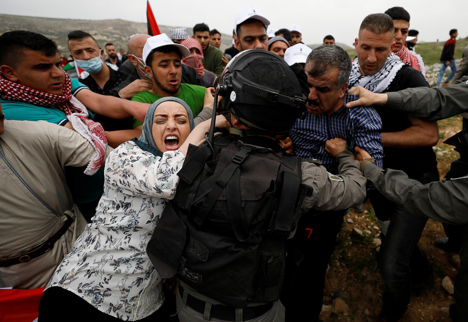 Palestinians try to prevent Israeli troops from detaining a protester during a protest marking Land Day in the West Bank village of Madama, near Nablus. PHOTO: REUTERS