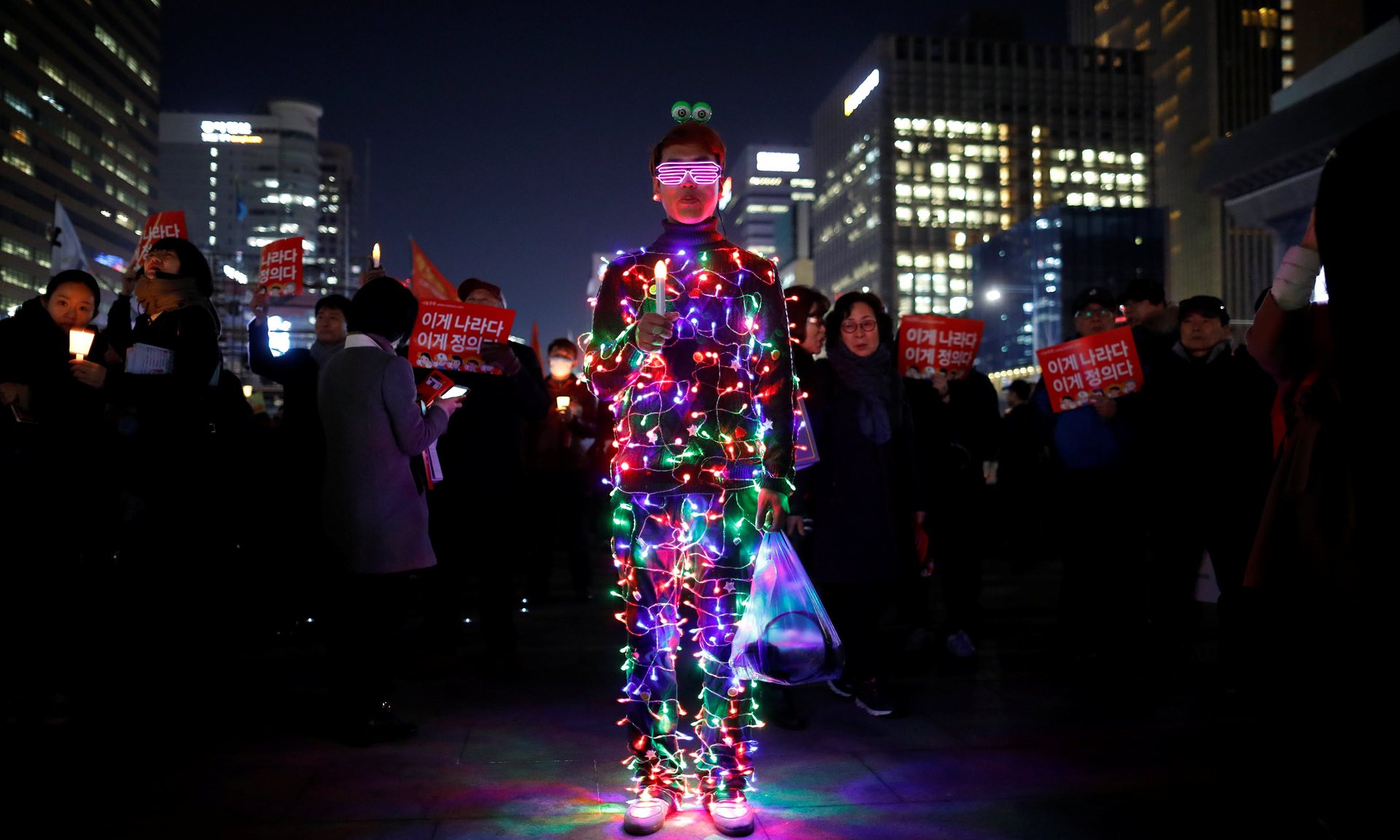 A demonstrator is illuminated by LED bulbs during a rally calling for impeached president Park Geun-hyeâs arrest, Seoul, South Korea. PHOTO: REUTERS