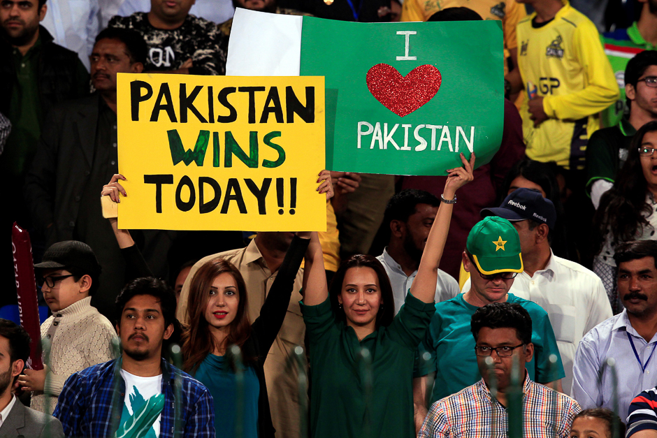 Pakistani spectators hold placards at Gaddafi Cricket Stadium as they wait for the start of a hugely anticipated finals of its domestic cricket league. PHOTO: REUTERS