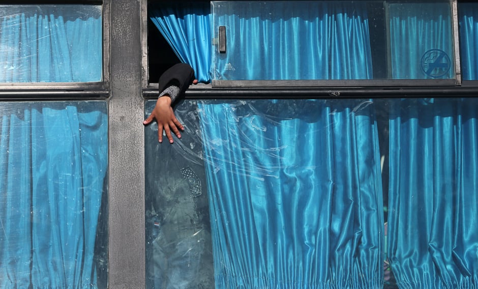 A Palestinian boy puts his hand out of a bus window as he waits with his family to cross into Egypt through the Rafah border crossing after it was opened by Egyptian authorities for humanitarian cases, in Rafah in the southern Gaza Strip. PHOTO: REUTERS