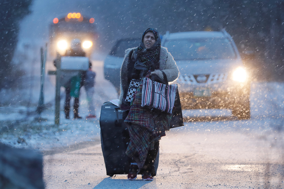 A woman walks towards the border to cross at the US-Canada border after arriving in a taxi with a group that claimed to be from Syria into Hemmingford, Quebec, Canada. PHOTO: REUTERS