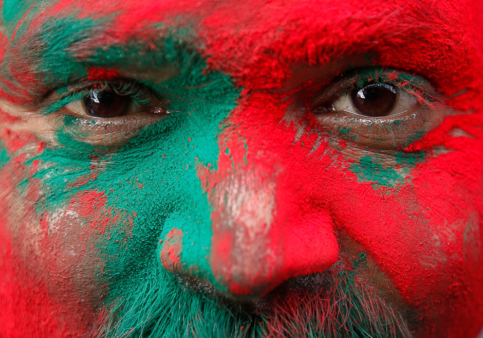 A Hindu devotee is covered in coloured powder as he stands outside a temple during the religious festival of Holi in Vrindavan, in the northern state of Uttar Pradesh, India. PHOTO: REUTERS